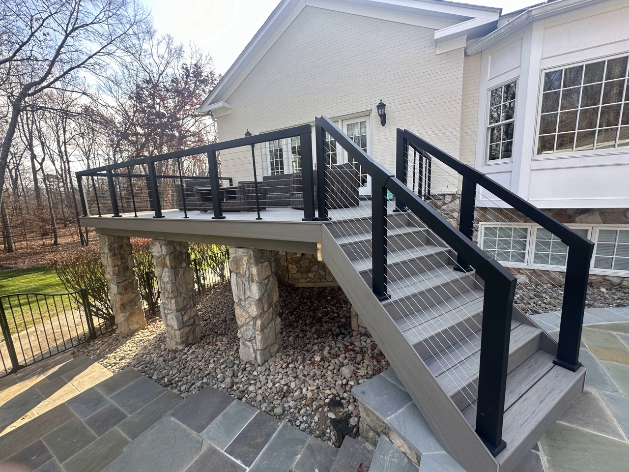 Elegant TimberTech Deck with Modern Cable Railings and Stone Accents